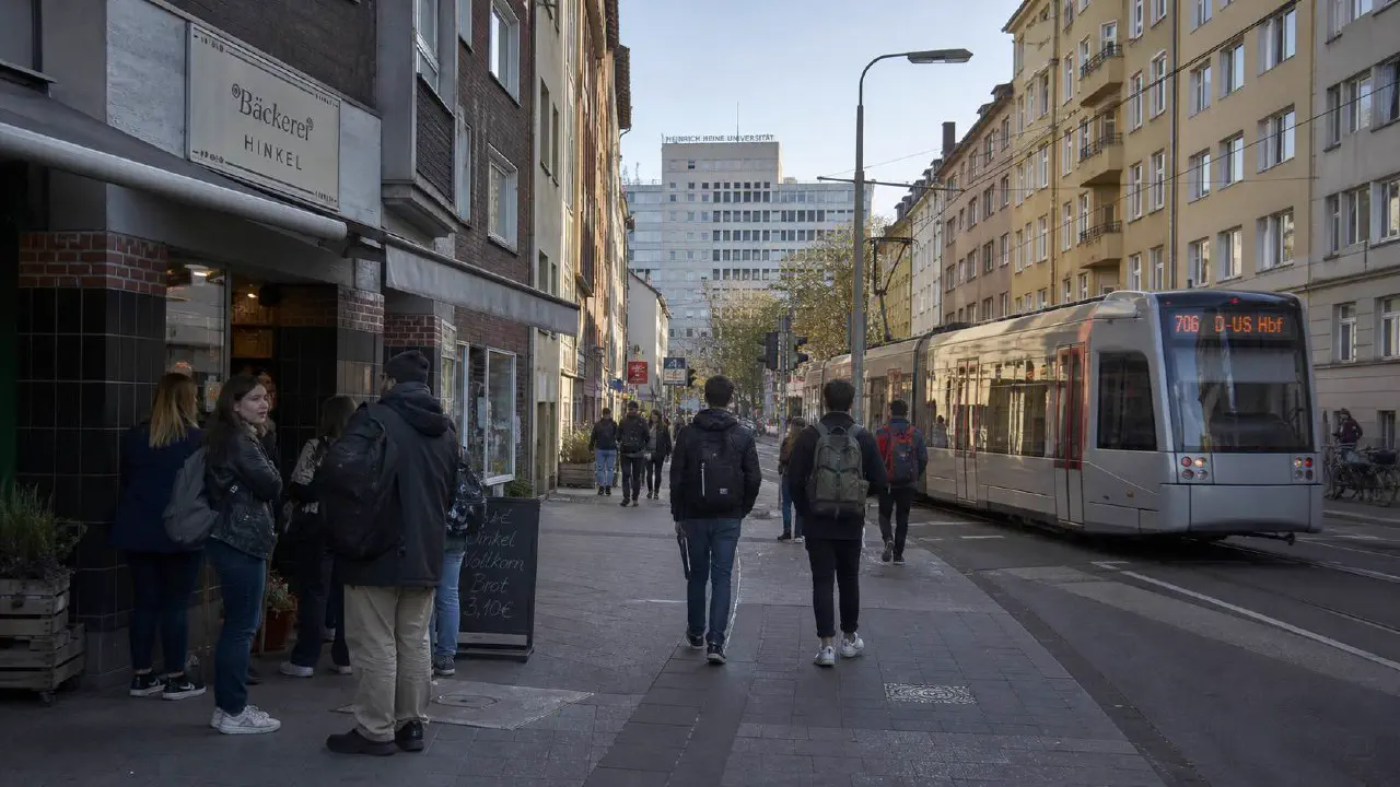 Bilker Allee in Düsseldorf-Bilk mit gemischter Bebauung aus Gründerzeit-Mietshäusern, Studentencafés und der Schnabel-Kuppel des botanischen Universitätsgartens