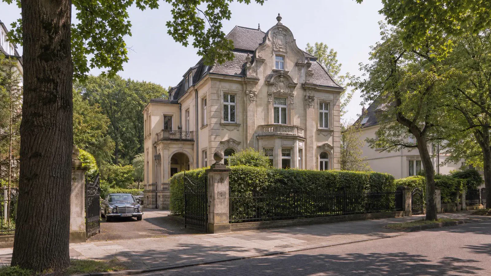 Jugendstil-Villa am Decksteiner Weiher in Köln-Lindenthal mit Wintergarten, altem Baumbestand und schmiedeeisernem Gartenzaun, parkartige Ruhe am Stadtwald